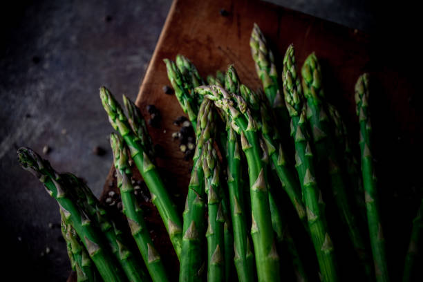 istock Fresh green asparagus on wooden cutting board. 1407225826