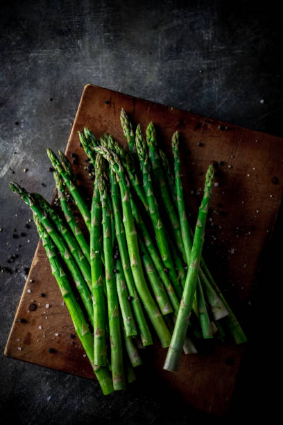 istock Fresh green asparagus on wooden cutting board. 1407231668