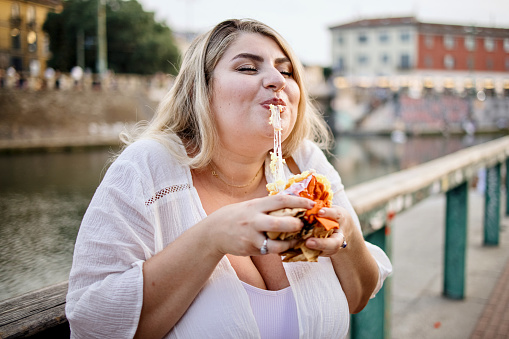 Close up of a woman eating Arancini in Italy