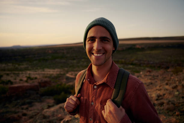 istock Smiling male hiker with backpack during sunrise looking at camera 1407238985