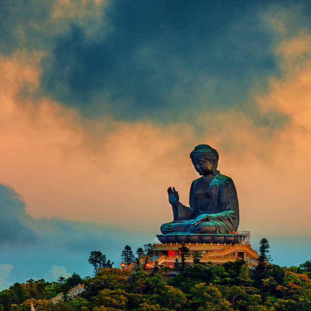 Big Buddha sitting atop the peak of Mount Muk Yue on Lantau Island Big Buddha sitting atop the peak of Mount Muk Yue on Lantau Island tian tan buddha stock pictures, royalty-free photos & images