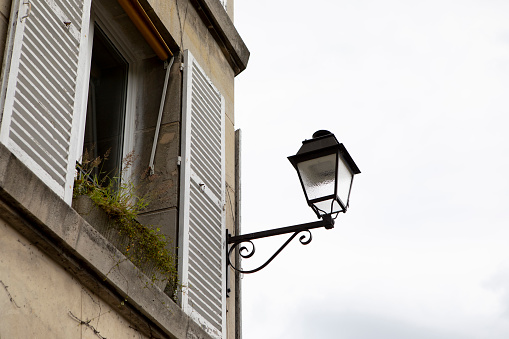 Street lamp on a wall in a narrow street.