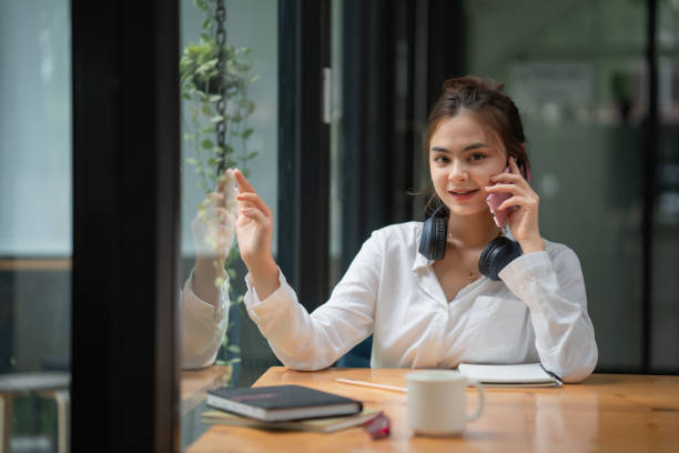 istock Pretty woman talking on mobile phone in home office 1407243354