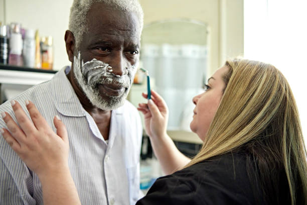 pracownik służby zdrowia pomagający starszemu klientowi w goleniu - shaving female shaving cream razor zdjęcia i obrazy z banku zdjęć