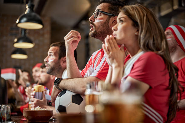 istock Soccer fans watching a game on TV in a pub. 1407245676