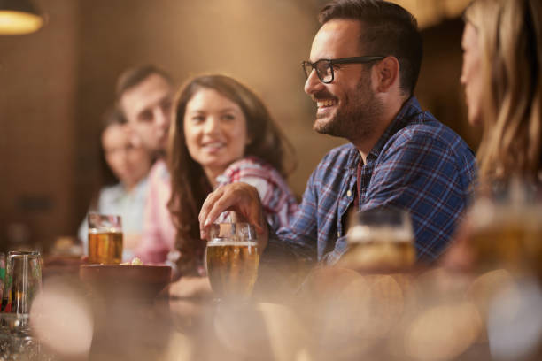 istock Young happy man drinking beer with his friends in a pub. 1407245930