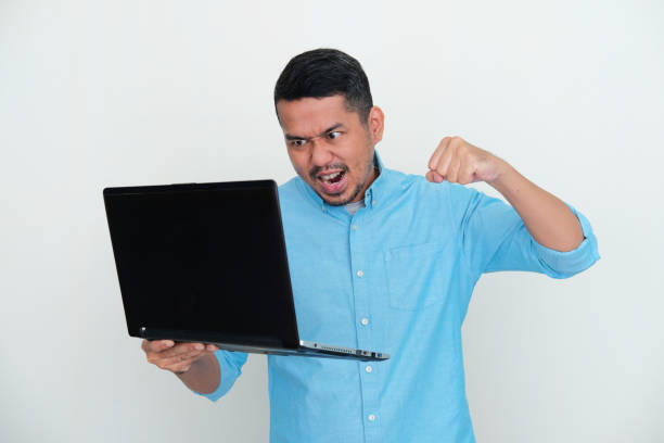 Adult Asian man want to punch his laptop with angry expression Adult Asian man want to punch his laptop with angry expression kantor stock pictures, royalty-free photos & images