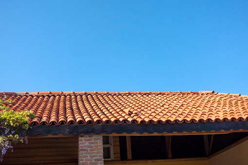 Roof tiles over home on a bright sunny afternoon with sky