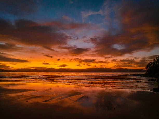 Winter sunrise at the seaside with high cloud and reflections stock photo