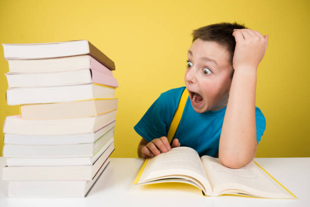 istock Scared student boy looking at pile of books 1407248962