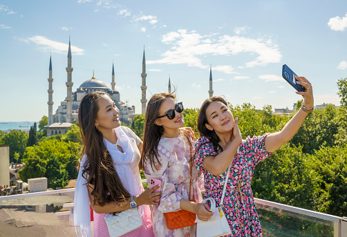 Portrait of cheerful girlfriends taking a selfie in front of the Blue Mosque in Istanbul, Turkey