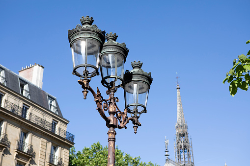 Street lights on Île de la Cite, Paris with the spire of Sainte-Chapelle in the distance