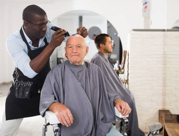 istock Elderly man getting haircutting from African barber 1407251952