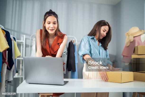 Asian Woman Friends Couple Packing Clothes Order Into Box For Customer Young Attractive Business People Work To Preparing Parcel Boxes Check Ecommerce Shipping Online Retail To Sell At Office Store Stock Photo - Download Image Now