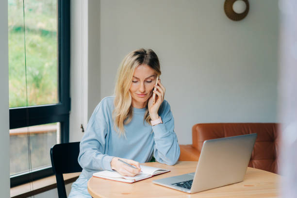 istock Businesswoman talking on the phone while working at home. 1407257251