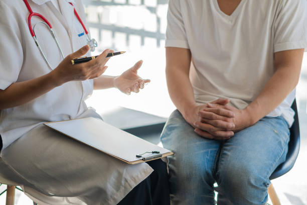 les médecins parlent aux patients dans le bureau de la clinique. l’accent est mis sur le stéthoscope et le patient consulte et diagnostique, s’assoit et parle. à la table près de la fenêtre dans hospital medical concept - hiv photos et images de collection