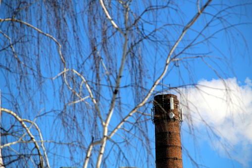 External view of the modern biomass co-generation power plant with smoking chimney on the beautiful blue sky background