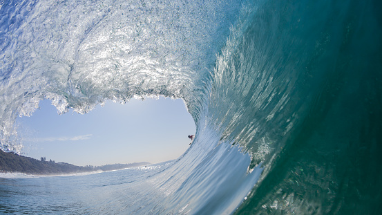 Surfing ride inside hollow ocean sea wave swimming close-up water photo of scenic moment.