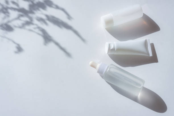 istock Cosmetic bottles with leaf shadow on white wall background 1407260718