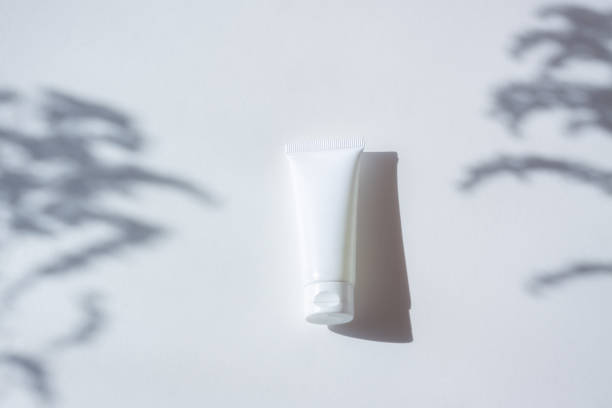 istock Cosmetic bottle with leaf shadow on white wall background 1407260740