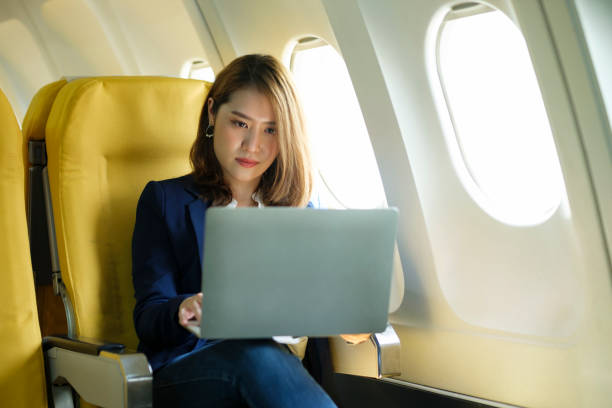 istock Business woman In a plane, works on using laptop computer. 1407261767