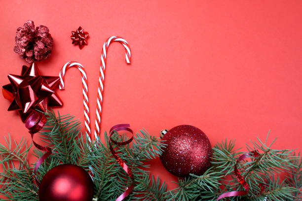 istock On a red background are candy cane and Christmas decorations and branches. 1407262044