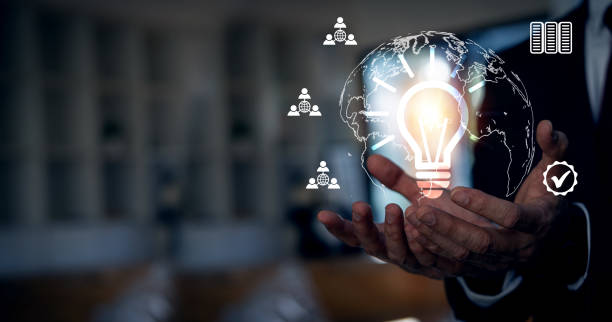 istock Businessman's hand holding a glowing light bulb with a world energy source icon. Environmentally friendly and sustainable campaign with social network diagrams, concept icons, energy saving 1407264153