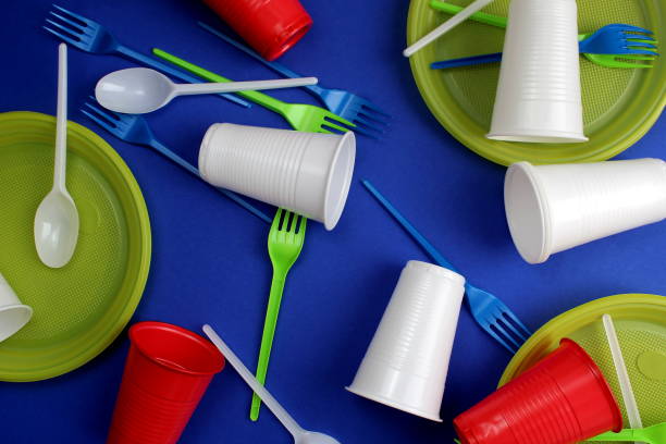 istock Disposable tableware in a pile lie on a blue background. 1407264315
