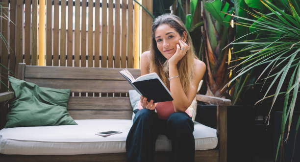 istock Happy woman reading book on terrace 1407264648