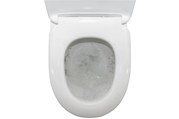 istock Water flushing down toilet bowl, top view, isolated on white background. 1407264790
