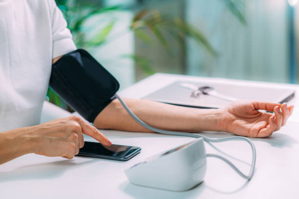 istock Measuring Blood Pressure, Using Smartphone to Follow Results 1407265576