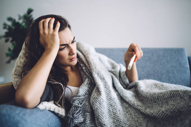 istock Thoughtful young woman with high temperature resting at home 1407265622
