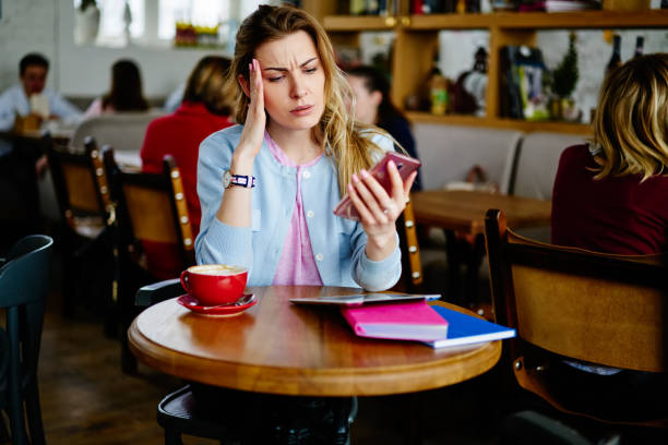 istock Thoughtful young woman with smartphone and tablet during remote work in cafe 1407266442