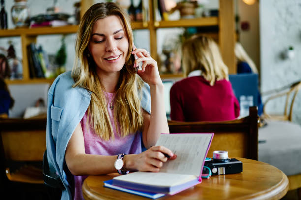 istock Young woman talking on smartphone in cafe sitting at table 1407266468
