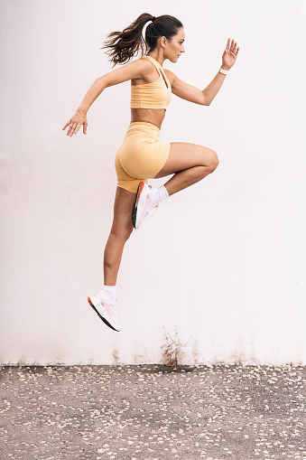 Isolated female athlete jumping outdoors