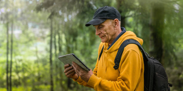 istock Mature tourist with backpack holds tablet in hands and looking map 1407267923
