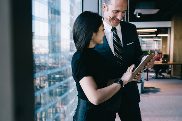 istock Smiling diverse coworkers surfing Internet on tablet in office 1407267963