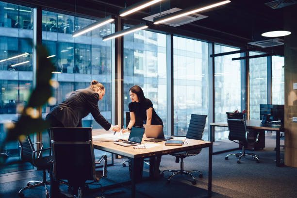 Confident male and female architects talking to each other brainstorming and cooperate on project in office interior, intelligent business partners preparing finance report communicating and analyzing arquitectos y arquitectas seguros de sí mismos hablando entre sí haciendo una lluvia de ideas y cooperando en el proyecto en el interior de la oficina, socios comerciales inteligentes que preparan informes financieros comunicándose y analizando