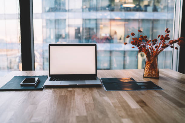 istock Laptop and smartphone on office table with decorative vase 1407268948