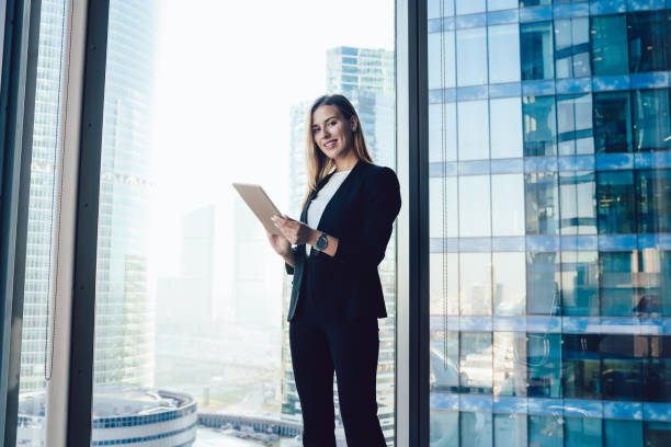 istock Smiling businesswoman using tablet in modern office building 1407269000