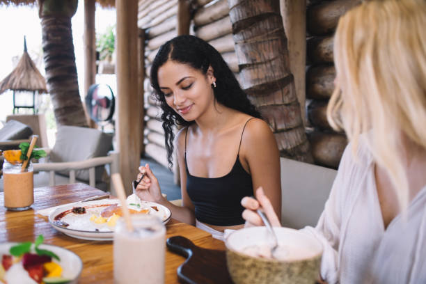 istock Smiling woman eating breakfast in cafe 1407269906