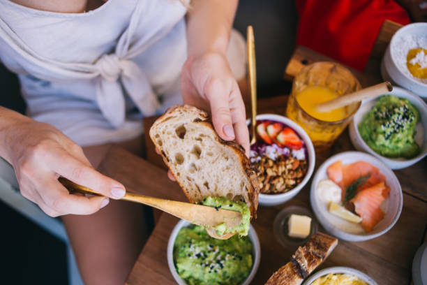 istock Crop woman putting avocado sauce on bread 1407270774