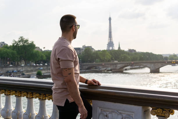istock Young boy looking at the eiffel tower and the seine river from a bridge in paris 1407271416