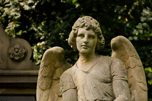 Weathered old angel statue in a cemetery in Germany