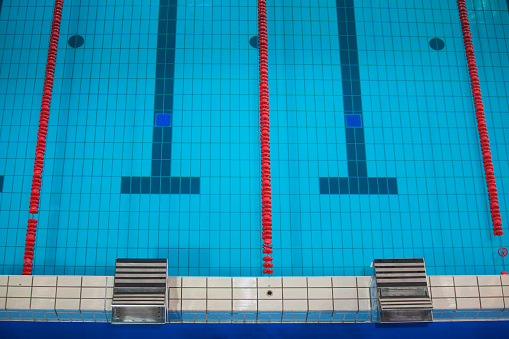 Empty swimming pool with swimming lane markers ready for competition. Shot from above.