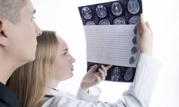 istock Epileptologist examines patient MRI and electroencephalogram. Concept treating epilepsy and helping people who suffer from this disease. Neurologist at work. Pathology of the brain. Seizure activity 1407275512