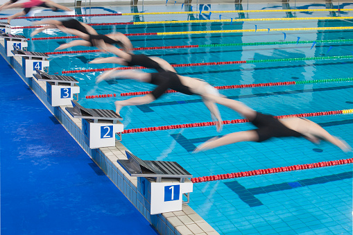 Freestyle stroke swimming competition start for women at a swimming tournament.