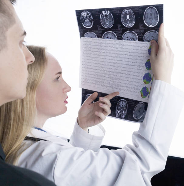 istock Epileptologist examines patient MRI and electroencephalogram. Concept treating epilepsy and helping people who suffer from this disease. Neurologist at work. Pathology of the brain. Seizure activity 1407275707