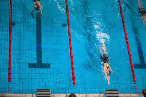 Freestyle stroke swimming competitor closing to finish line.
