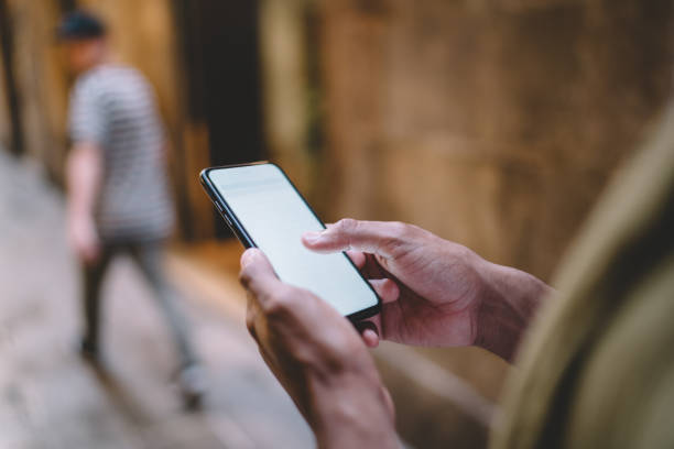 istock Crop person using smartphone on street 1407277189